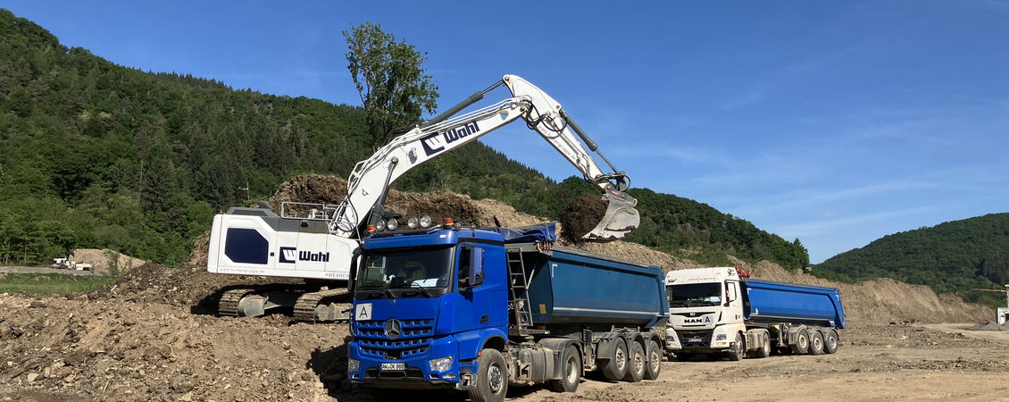 Ein LKW wird von einem Bagger beladen