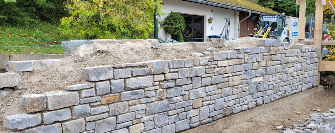 Bauarbeiten an der neuen Stützmauer des Friedhofs Rech